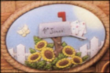 Ovales Schild mit Briefkasten und Blumen